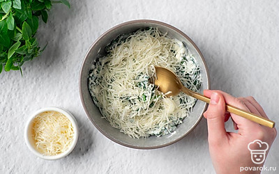 В отдельной миске размешайте сливочный сыр до однородной текстуры. Добавьте приготовленный шпинат, 50 г тертого сыра, пропущенный через пресс чеснок и паприку. Хорошо перемешайте соус.