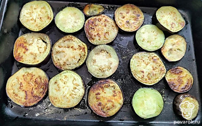 Баклажаны нарежьте кружочками толщиной около 1 сантиметра. Посолите, обжарьте на растительном масле до золотистого цвета. Выложите первым слоем в форму для запекания. 