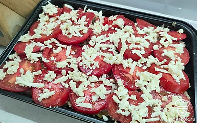 Брынзу натрите на крупной терке и выложите на помидоры. 