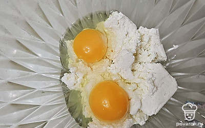 В отдельной емкости смешайте творог с яйцами. Добавьте сахар по вкусу, перемешайте. Всыпьте муку с разрыхлителем и еще раз перемешайте до однородной консистенции. 