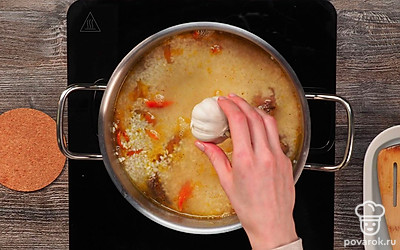 Сделайте плов в кастрюле. Как вода закипит, убавьте пламя до минимума и оставьте на 20 мин. За 5 мин до готовности положите очищенные зубчики чеснока в плов.