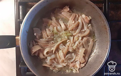 Добавьте нарезаные кальмары. Посолите, поперчите. Обжарьте кальмары с луком и чесноком на сильном огне 2-3 минуты, постоянно помешивайте.