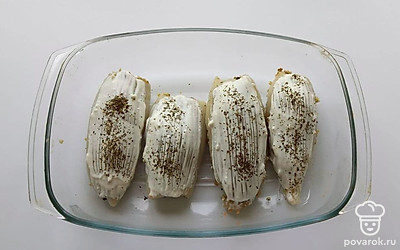 Зафаршируйте кальмары полученной смесью. Смажьте сверху греческим йогуртом, посыпьте специями и отправьте в разогретую до 180 градусов духовку на 20 минут.