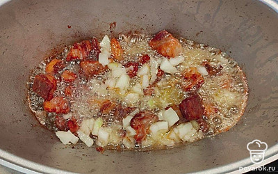 Достаньте из казана чеснок обжаренный и выложите сало (грудинку). Обжаривайте на сильном огне, помешивая постоянно. Потом добавьте лук. Обжаривайте все вместе и добавьте морковь, посыпьте немного соли.