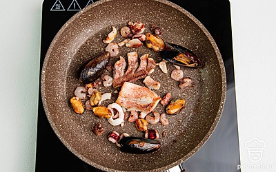 Разогрейте сковороду и налейте на нее немного оливкового масла. Обжарьте вместе рыбу, мидии, кальмары, креветки и гребешки. Примерно 5-7 минут.