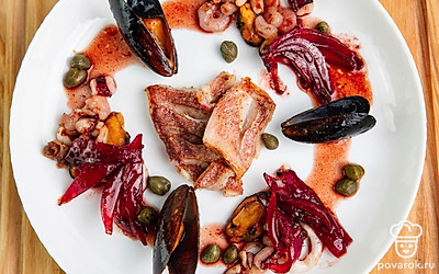 Выложите рыбу и морепродукты на плоскую тарелку. Полейте винным соусом, пассированный лук из соуса также можно подавать к готовому блюду. Посолите и поперчите по вкусу.