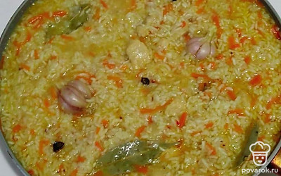 После, откройте крышку и аккуратно перемешайте рис. Воткните чеснок в рис и варите еще 10 минут. Через 10 минут выключите огонь и достаньте чеснок из риса. Закройте казан (сковороду) и дайте плову постоять 10 минут.