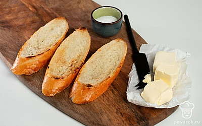 Приготовьте хлеб. Ломтики багета смажьте сливочным маслом, сверху посолите. Подсушите в духовке до золотистого цвета 5-7 минут при 200-220 градусах. Остудите.