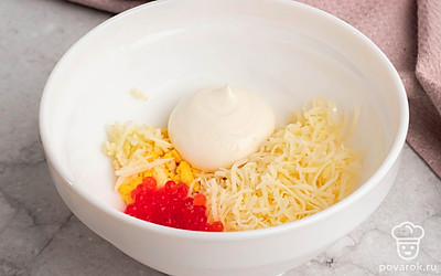 Смешайте майонез, желток, красную икру, сыр и чеснок в отдельной миске. Посолите и поперчите получившеюся начинку для яиц.