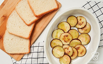 Запеките баклажаны. Порежьте баклажан кружками толщиной 1,5 см. Смажьте противень растительным маслом и выложите на него ломтики баклажана, посолите и запеките на протяжении 8 минут.