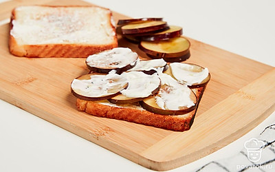 Приготовьте тосты с баклажаном. Выдавите зубчики чеснока в емкость. Смешайте чеснок и майонез до образования однородной массы. Намажьте на готовые тосты смесь из чеснока и майонеза. Сверху выложите баклажаны. Поверх баклажанов выложите также чесночную смесь.