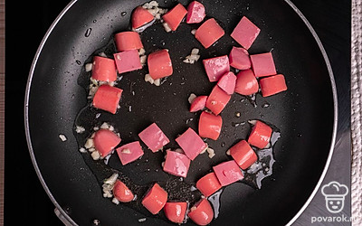 Сковороду поставьте на огонь, налейте небольшое количество масла и обжарьте сначала чеснок (он придаст блюду неповторимый аромат). Затем обжарьте до золотистого цвета сосиски.