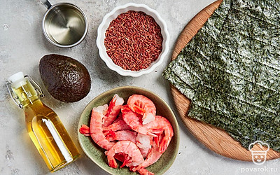 Красный рис промойте, отварите до готовности в течение 30 минут. У авокадо удалите косточку, мякоть порежьте кубиками небольшого размера. Лангустины при необходимости разморозьте и почистите. Подготовьте циновку для сворачивания роллов.