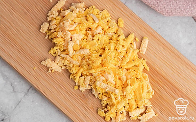 Вынутый желток и мелко покрошите его в отдельную миску. Натрите чеснок и сыр на терке.