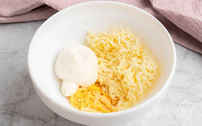 Смешайте майонез, желток, сыр и чеснок в отдельной миске. Посолите и поперчите получившеюся начинку для яиц.