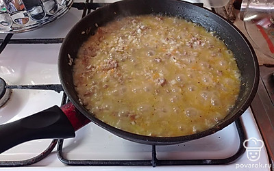 На среднем огне помешивая рис с мясом, дать воде выпариться, после этого выключить огонь, добавить измельчённый чеснок, накрыть сковороду фольгой и дать потомиться минут 15-20.