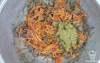 Затем всыпьте нарезанную соломкой морковь, присыпьте специями и солью, перемешайте и жарьте еще в течение 7-8 минут.