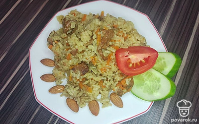 Подавайте плов горячим на блюде, присыпав измельченным миндалем с нарезанными сезонными овощами.