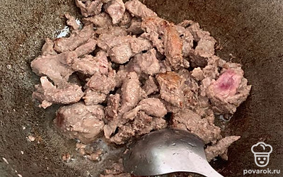 На сильно раскаленное масло в казан отправляем жарить мясо до красной корочки.