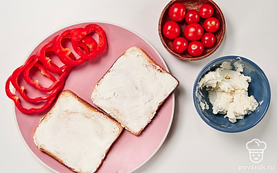 Подготовьте основу для тостов. Подогрейте хлеб для тостов в тостере, выставив таймер на 30 секунд. После приготовления тостов намажьте на них творожный сыр.