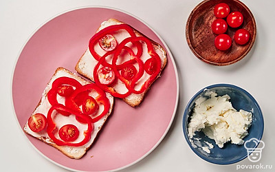 Добавьте овощи. Сверху на творожный сыр положите кольцами нарезанный перец, а затем помидоры.