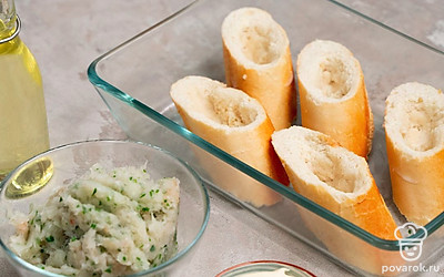 Выложите багет на противень. Налейте в миску сливки. Багет нарежьте ломтиками толщиной 2-3 см. Опустите кусочки хлеба в сливки на несколько секунд, чтобы они хорошо пропитались влагой. Затем отожмите лишнюю жидкость и разложите на противне или в форме для запекания. Сделайте углубление в каждом кусочке.