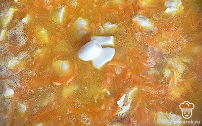 Выложите рис и налейте столько воды, чтобы полностью его покрыть. Положите в середину чеснок, 2-3 зубчика.