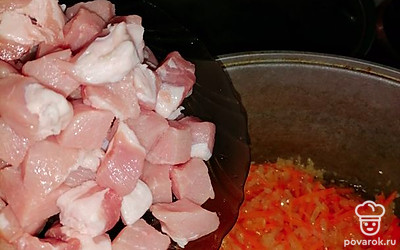 К обжаренным овощам добавить нарезанную средними кусочками свинину. Посолить, поперчить и жарить до золотистого цвета. 