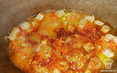 Высыпать к обжареному мясу с овощами промытый рис. Выложить приправу для плова. 