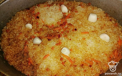 В готовый плов добавить несколько зубчиков чеснока. Блюдо готово. 