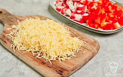 Подготовьте ингредиенты. Нарежьте перец мелкими кубиками, измельчите крабовые палочки. Натрите сыр на терке с маленькими отверстиями.