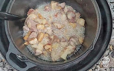 После того как сало вытопится, добавить в казан мясо, нарезанное средними кусочками.