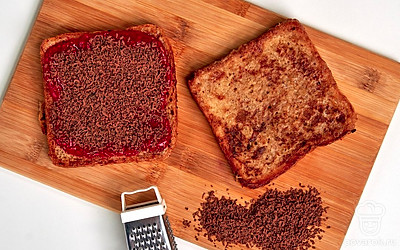 Приготовьте тосты. Выложите ягоды малины в миску и перебейте блендером до состояния пюре. Добавьте сахар и перемешайте до полного растворения. Выложите полученное пюре на половину поджаренных тостов густым слоем, сверху посыпьте тертым шоколадом и накройте оставшимися тостами.