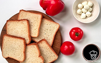 Подготовьте необходимые продукты, удобно расположите их на рабочем столе. Вымойте помидоры и болгарский перец. У помидоров вырежьте место крепления плодоножки, у болгарского перца удалите плодоножку, семена и внутренние перегородки. Зелень для подачи вымойте, обсушите на бумажных полотенцах, измельчите.