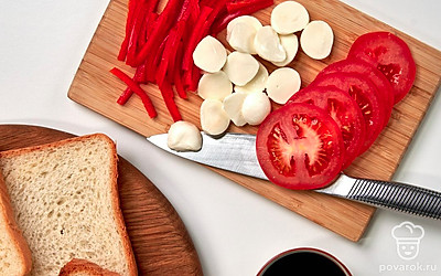 Подготовьте продукты для тостов. Помидоры нарежьте кружочками, болгарский перец — полосками, моцареллу — половинками.