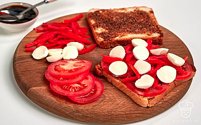 Подготовьте тост к подаче. Смажьте ломтики хлеба соусом барбекю. Выложите сверху нарезанные овощи. Завершите композицию сыром. Поставьте в микроволновую печь на минуту.