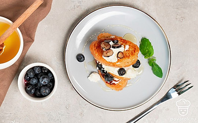 Подавайте тосты с медом, украсив их ложкой рикотты, свежей голубикой или любыми ягодами по вкусу.