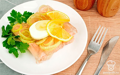 Подавайте заливное из горбуши с лимоном и свежей зеленью.