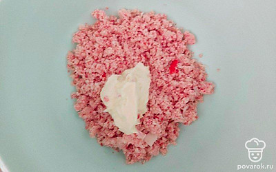 Отдельно натрите на терке крабовые палочки. Из сырной массы слепите небольшие шарики и обкатайте их в крабовой стружке.