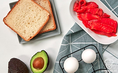 Авокадо вымойте, разрежьте пополам, очистите от кожуры, уберите косточку. Нарежьте пластинками толщиной около 0,5 см. Семгу нарежьте тонкими слайсами. Маслины для подачи нарежьте кружочками.