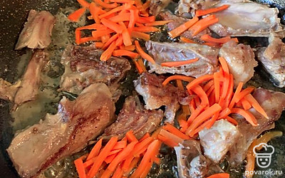 Мне попалась довольно жирная утка, но все же для обжарки нужно добавить растительное масло. Обжарить мясо до красивой корки. Затем залить водой и тушить. Добавить морковь, обжаривать 5-7 минут.