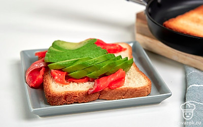 Соберите тост. Подсушите хлеб в тостере или на сковороде. Выложите на тосты ломтики семги. Сверху добавьте авокадо, а на него отправьте яйцо пашот.