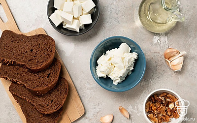 Хлеб нарежьте на куски толщиной около 1 см. Грецкие орехи переберите от сора и помойте. Чеснок почистите и пропустите через пресс. Подготовьте блендер.