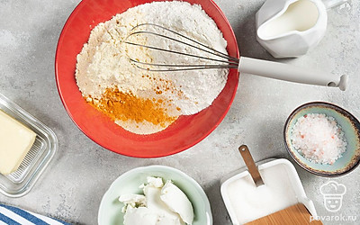 Замесите тесто. Смешайте оба вида муки, соль, сахар, дрожжи и куркуму. Добавьте теплое молоко. Замесите мягкое эластичное тесто и выложите его в миску, смазанную маслом. Накройте миску полотенцем и оставьте в теплом месте на 1 час.