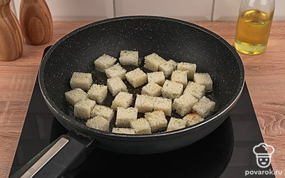 Возьмите сковороду, смажьте ее подсолнечным маслом и разогрейте. На разогретую сковороду выложите нарезанные кубики пшеничного хлеба так, чтобы они не перекрывали друг друга.