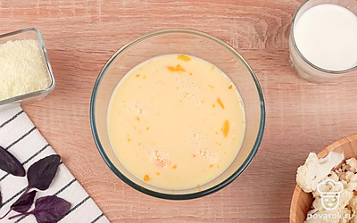 Разбейте куриные яйца в миску. Взбейте их с помощью вилки. Параллельно вливайте в миску молоко. Добавьте соль и черный молотый перец по вкусу, затем перемешайте.