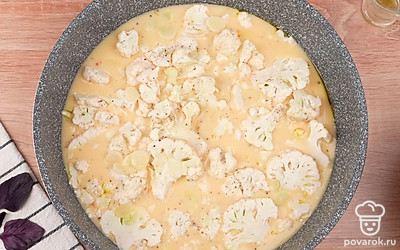 Залейте цветную капусту смесью яиц и молока. Посыпьте сверху тертым сыром. Накройте крышкой и обжаривайте на тихом огне 8-10 минут. Фритатта готова!