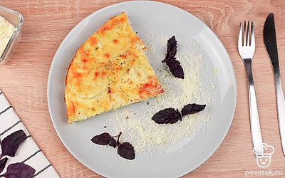 Порционно выложите фриттату на тарелки. Посыпьте тарелку тертым сыром. Украсьте тарелку листьями базилика. Поперчите и посолите по вкусу. Приятного аппетита!