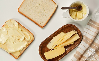 Подготовьте тосты. Хлебные ломтики разделите на две части. На три из них выложите сыр и небольшой кусочек сливочного масла. Получившиеся бутерброды накройте ломтиками оставшегося хлеба.