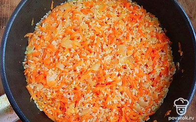 Далее обжарьте лук и морковь до полуготовности. Добавьте мякоть курицы, еще немного обжарьте. В конце добавьте рис. Он тоже должен обжариться.